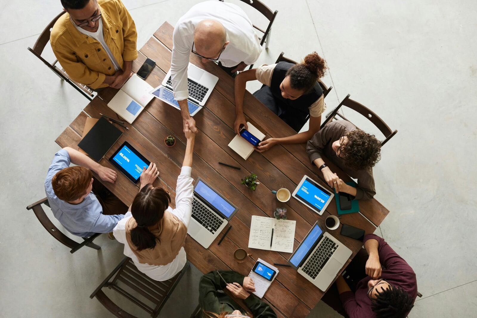 Leadership team collaborating around conference table to align vision, drive team performance, and foster organizational cohesion through fractional leadership alignment services.