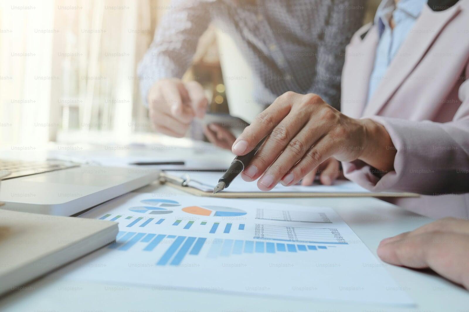 Business professionals analyzing financial charts and data to develop strategic financial plans, cash flow optimization, and profitability improvements through fractional CFO services.